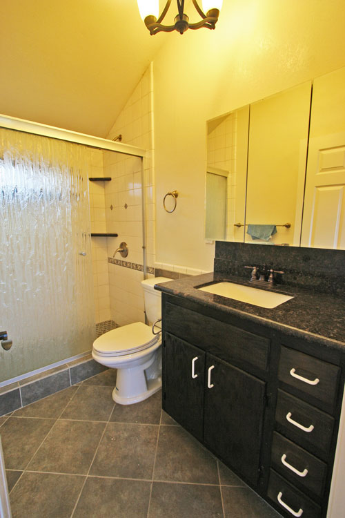 The main bathroom features granite and tile.