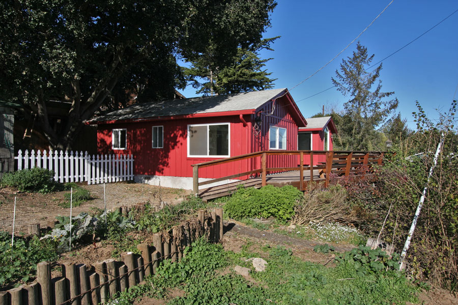The deck wraps around the house with access to a garden area and fenced back yard.