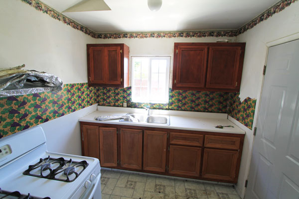 The kitchen is small but has outside door going to a patio.